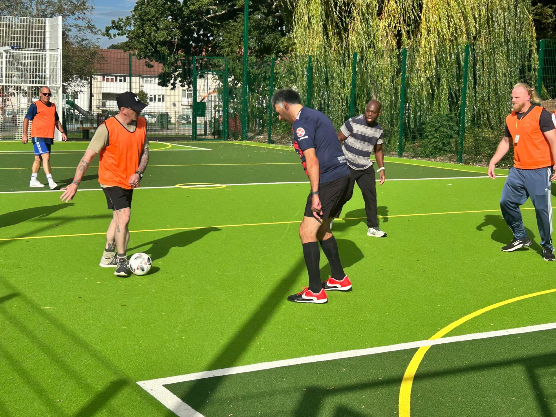 Men playing walking football on an outdoor pitch in Coventry